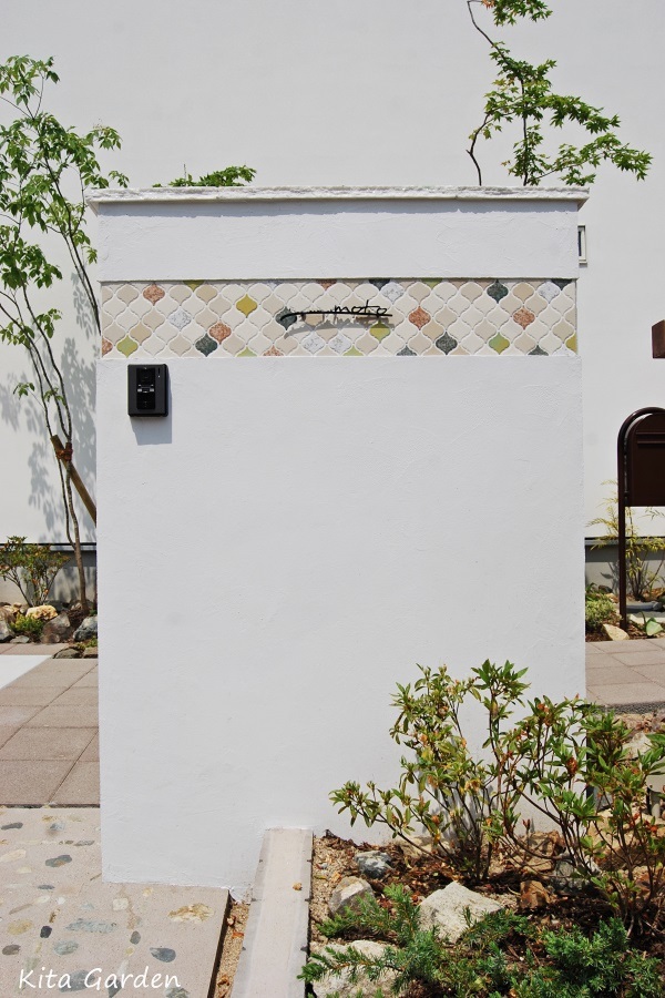 白の塗り壁とモザイクタイルのおしゃれな門柱