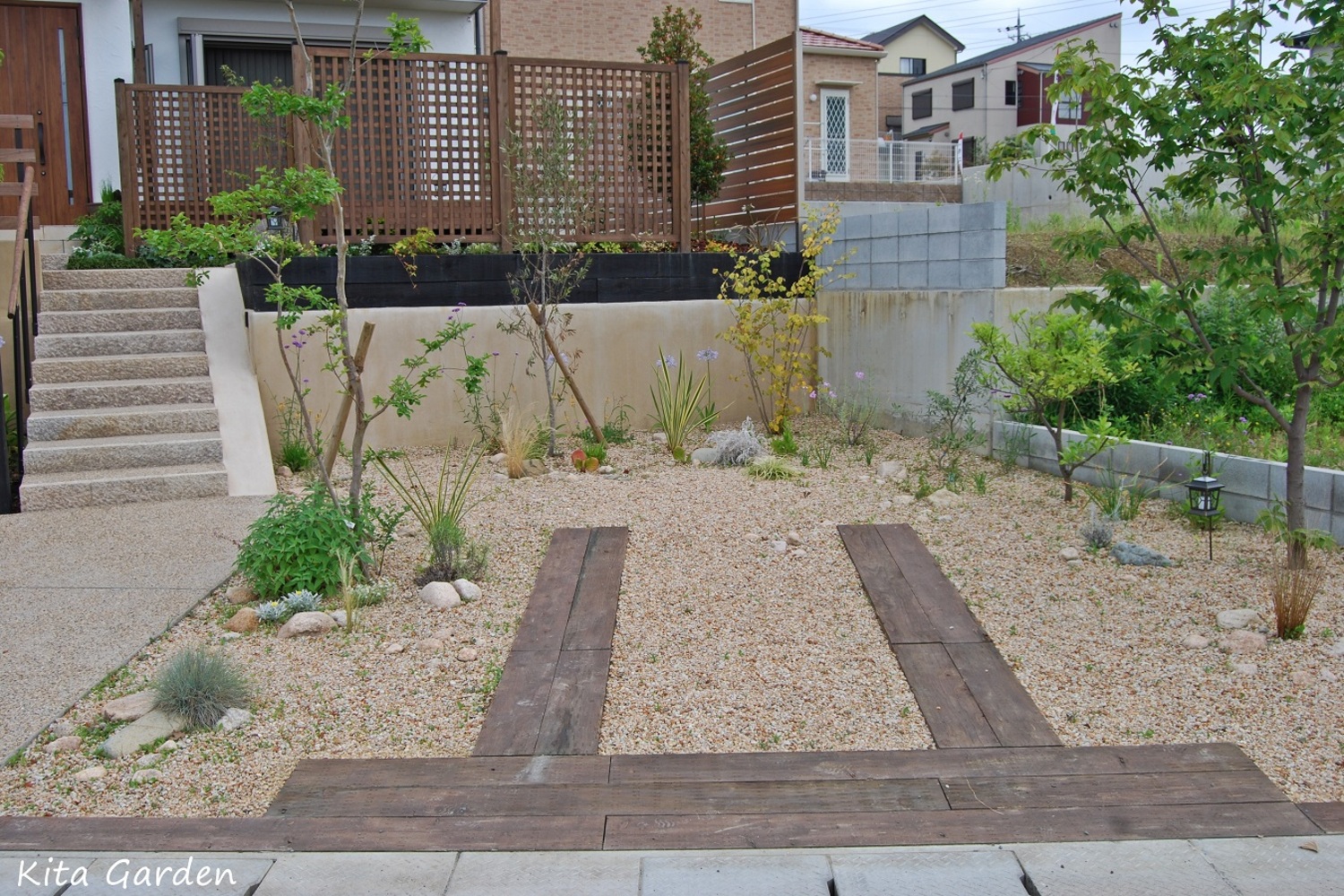 枕木と砂利を敷いたお庭のような駐車場デザイン