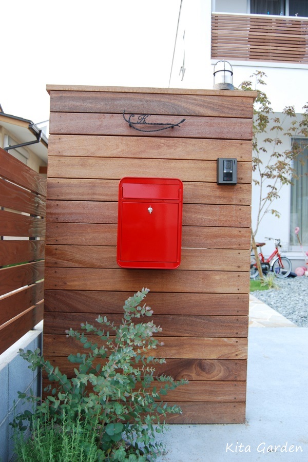 赤いデザインポストが印象的な木の板張り門柱