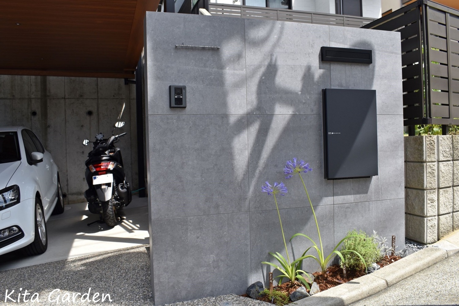 モダンなグレーのタイル門柱と黒の宅配ボックス