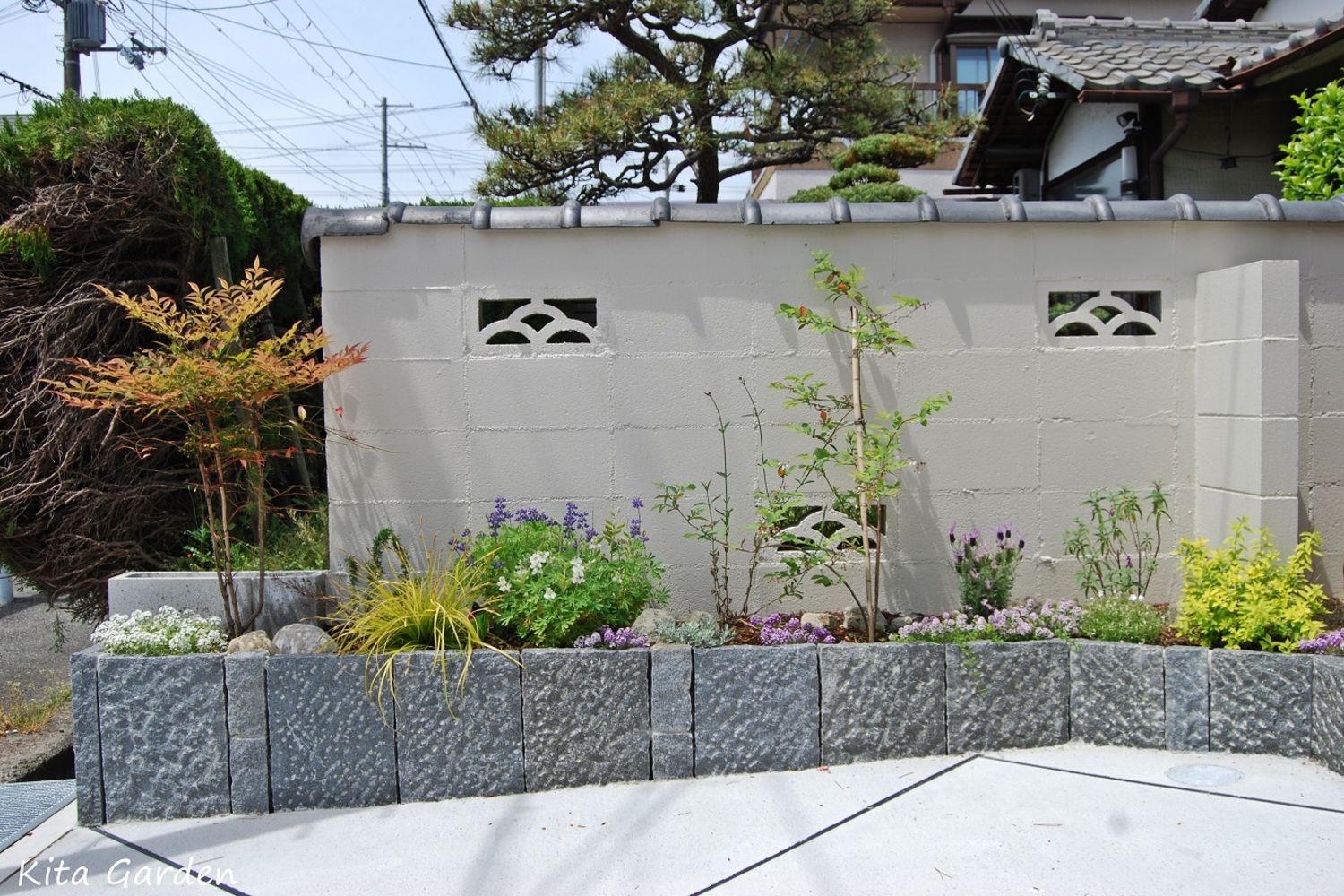 駐車場横の石の花壇と植栽