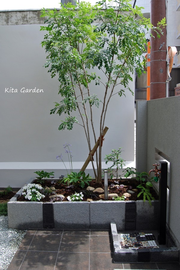 グレーの板石の花壇と植栽