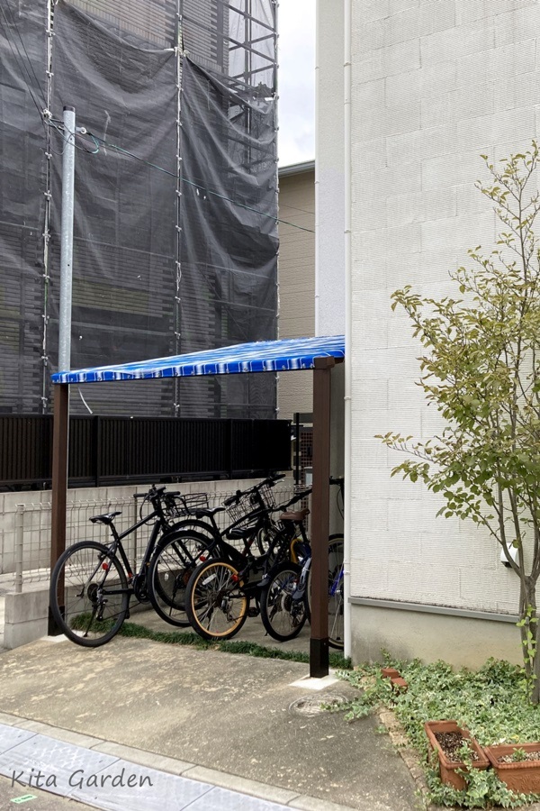 青い屋根の木製サイクルポート