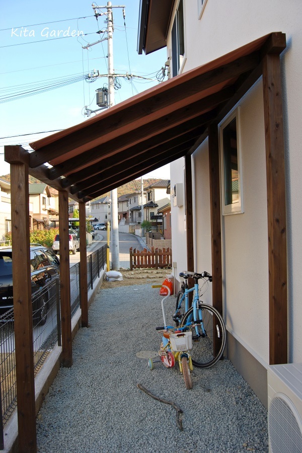 サーモン色の帆布をつけた自転車置き場の屋根