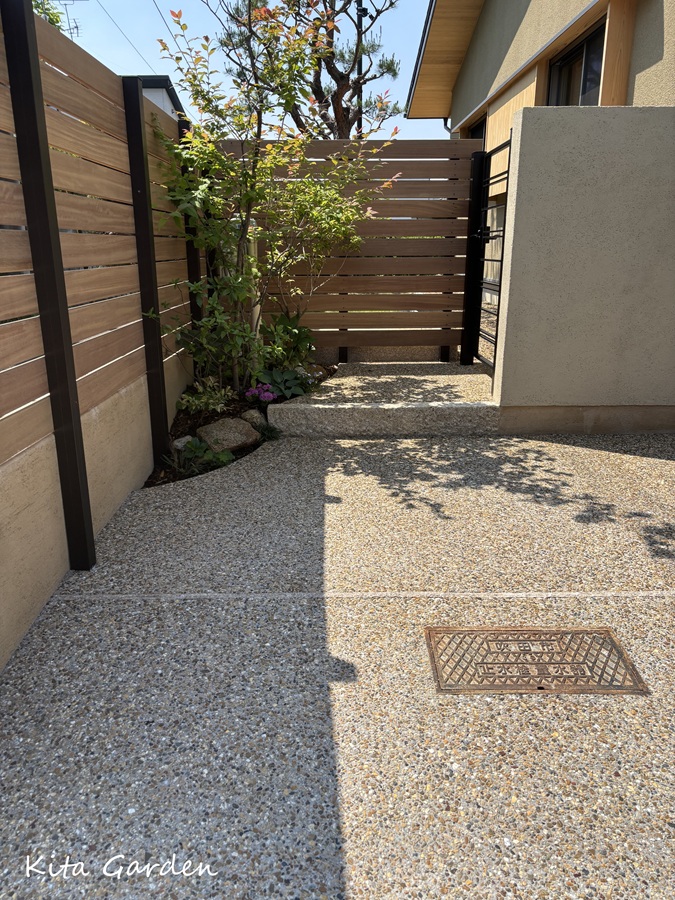 庭へと続く洗い出しのアプローチと植栽
