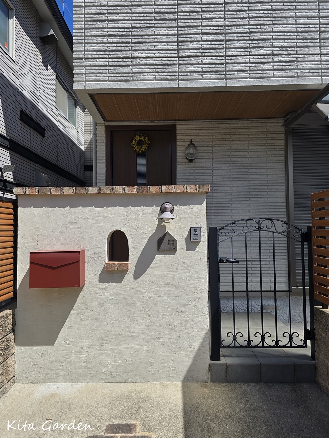 白い塗り壁とレンガ笠木の門柱